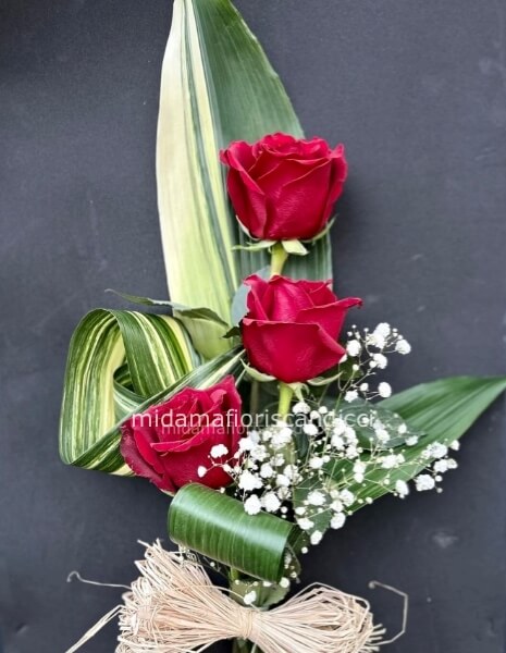 Tre rose abbracciate da un vestito verde